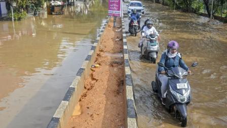 બ્રુહત બેંગલુરુ મહાનગરા પાલિકા (BBMP) ના કર્મચારીઓ બેંગલુરુમાં વરસાદ પછી પાણી ભરાયેલા રસ્તા પર અવરોધિત ડ્રેનેજ સાફ કરતાં હતા. (તસવીરો: મિડ-ડે)